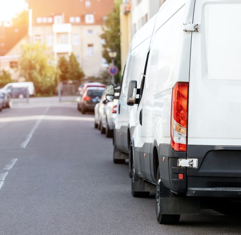 Small cargo delivery van parked in european city central district. Medium lorry minivan courier